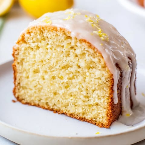 Fluffy golden Lemon Pound Cake, glistening with a tangy glaze, ready for a delicious dessert.