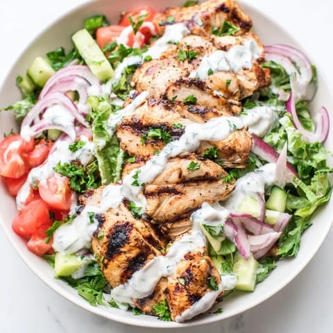 Sliced marinated chicken crowns a colorful Chicken Shawarma Salad greens and parsley, ready for a fresh lunch.