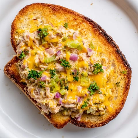 Spicy tuna melt features zesty tuna salad, gooey melted cheese, and crisp sourdough bread on a warm plate.  