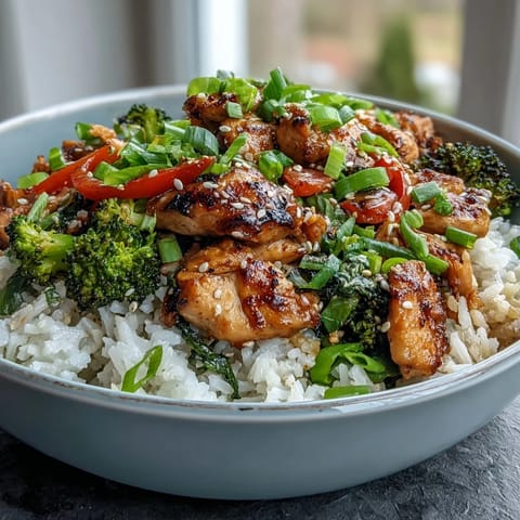 Tender marinated chicken and fluffy rice are topped with crisp broccoli in this wholesome Chicken and Rice Bowl.