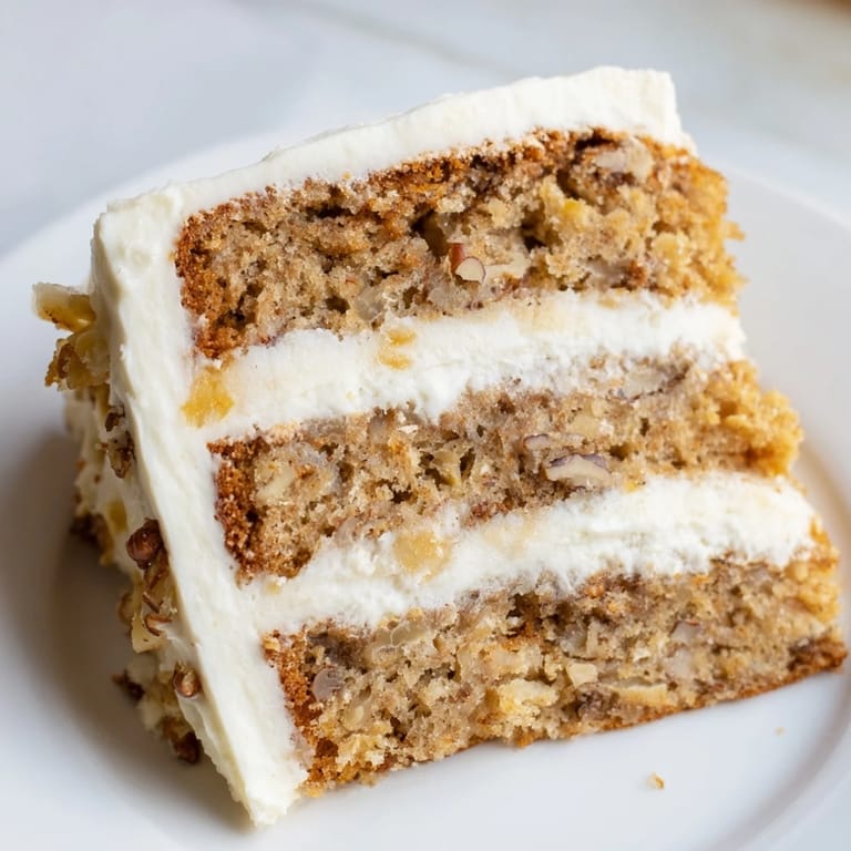 Warm, sweet Hummingbird Cake, showcasing layers of banana and pineapple, is perfect for sharing.