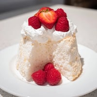 Fluffy angel food cake, golden and airy, perfect with fresh berries and whipped cream on top.