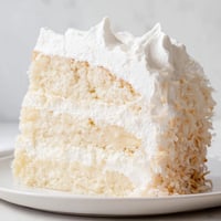 Fluffy layers of Coconut Cake, frosted with billowy meringue and topped with toasted coconut.