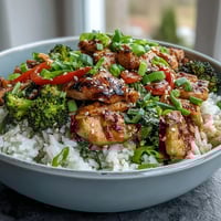 Tender marinated chicken and fluffy rice are topped with crisp broccoli in this wholesome Chicken and Rice Bowl.