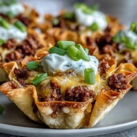 Crispy mini taco cups in wonton wrappers, a delightful appetizer with savory filling.